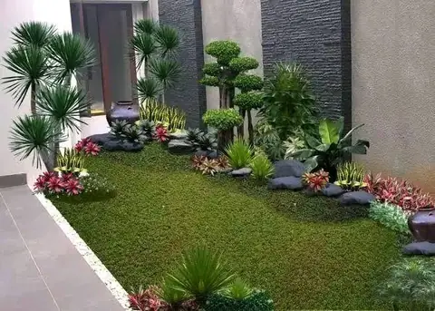 Gambar desain taman samping rumah dengan rumput dan batu hitam